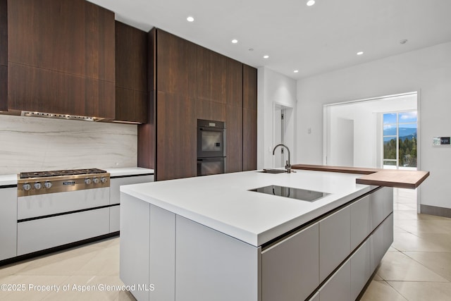 401 Eagle Park Dr, Aspen, CO 81611 - kitchen featuring black electric stovetop, light countertops, recessed lighting, stainless steel gas cooktop, and a sink