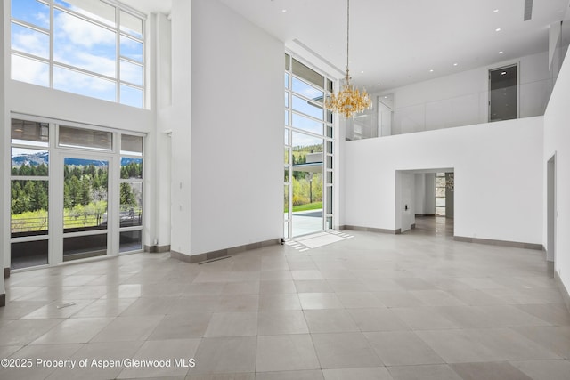 401 Eagle Park Dr, Aspen, CO 81611 - unfurnished dining area with a towering ceiling, a chandelier, baseboards, tile patterned floors, and recessed lighting