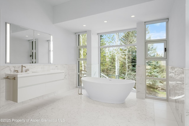 401 Eagle Park Dr, Aspen, CO 81611 - bathroom with a soaking tub, plenty of natural light, vanity, tile walls, and recessed lighting