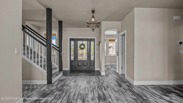 foyer entrance with an inviting chandelier and dark wood-type flooring