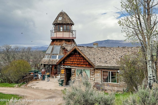 view of front of property featuring a mountain view and a balcony