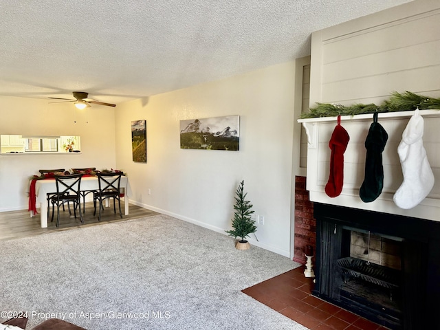 carpeted living room with a fireplace, a textured ceiling, and ceiling fan