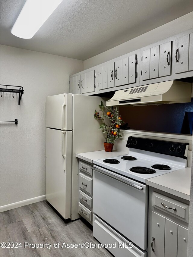 kitchen featuring light hardwood / wood-style flooring, white cabinets, a textured ceiling, and white electric range