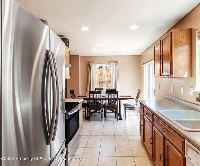 2618 Apache Ct, Rifle, CO 81650 - kitchen with appliances with stainless steel finishes, light tile patterned flooring, brown cabinets, light countertops, and recessed lighting