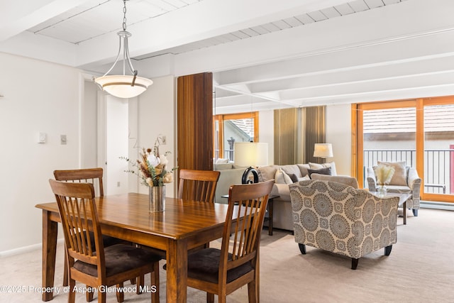 dining room featuring light carpet, baseboards, and beam ceiling