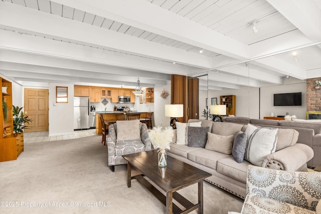 living room featuring baseboards, beam ceiling, and light colored carpet