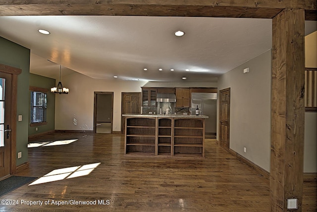 kitchen featuring dark hardwood / wood-style flooring, wall chimney exhaust hood, pendant lighting, an inviting chandelier, and stainless steel built in fridge