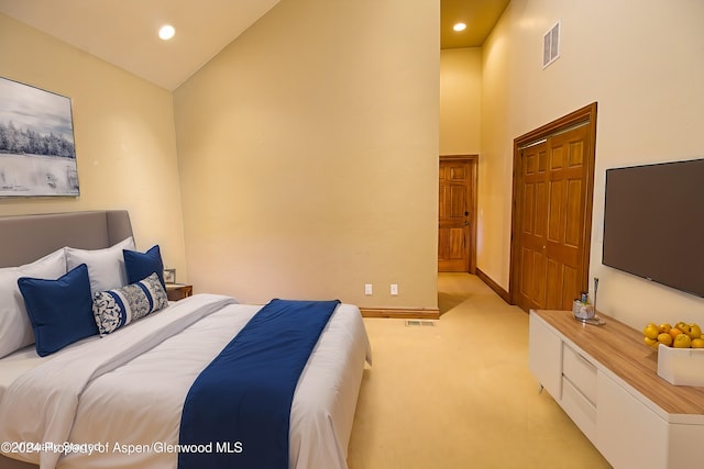 bedroom featuring light carpet and high vaulted ceiling