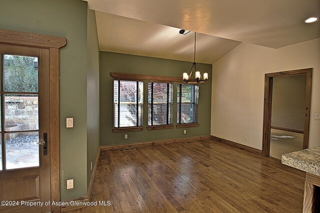 unfurnished dining area with dark wood-type flooring and a chandelier