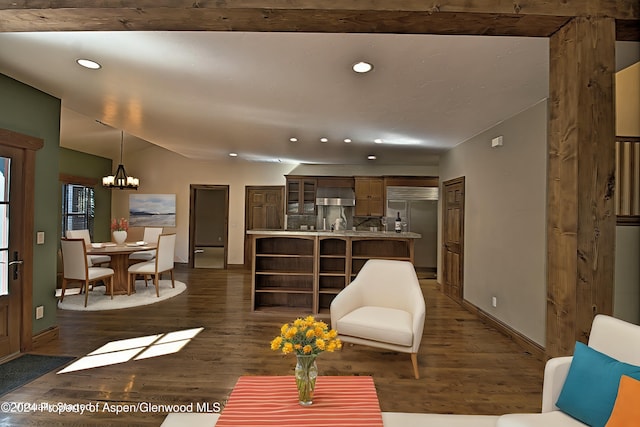 living room with dark hardwood / wood-style flooring, a chandelier, and vaulted ceiling