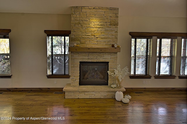 unfurnished living room with a fireplace and dark wood-type flooring