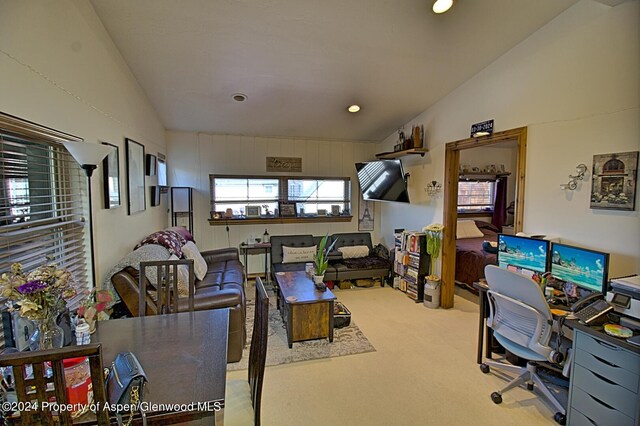 carpeted home office featuring vaulted ceiling