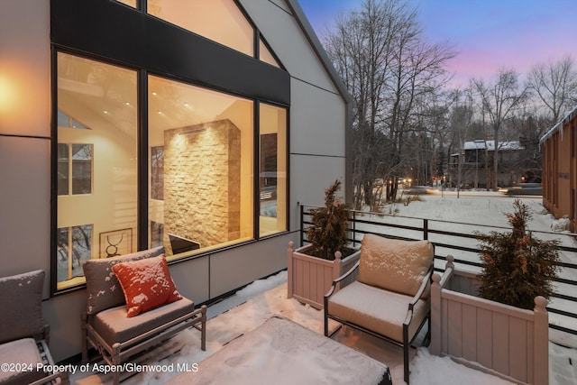 snow covered patio with a balcony