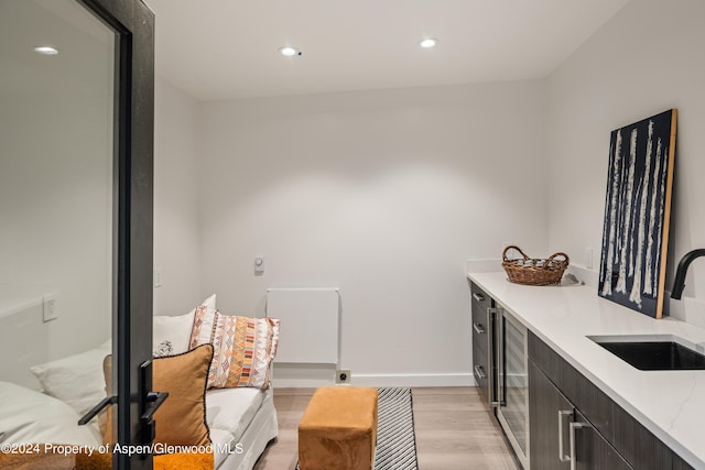 interior space featuring sink, beverage cooler, and light hardwood / wood-style flooring