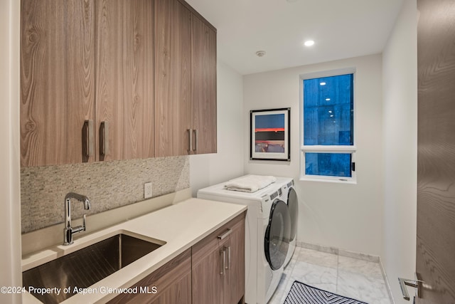 washroom featuring cabinets, sink, and washing machine and clothes dryer