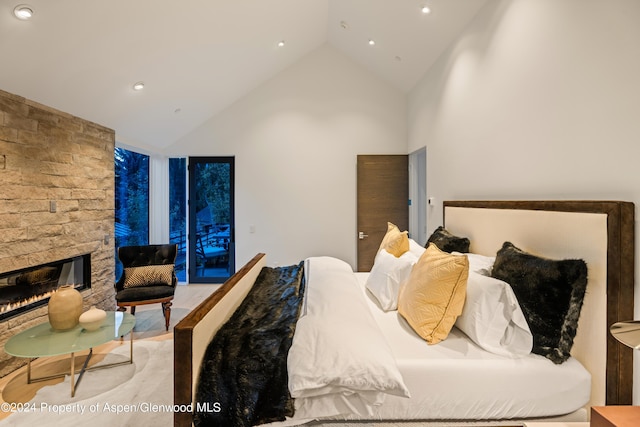 bedroom featuring a fireplace and high vaulted ceiling