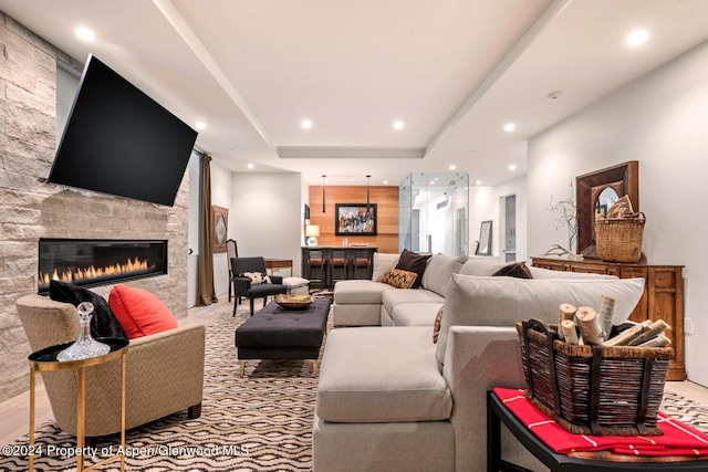 living room with a fireplace and a raised ceiling