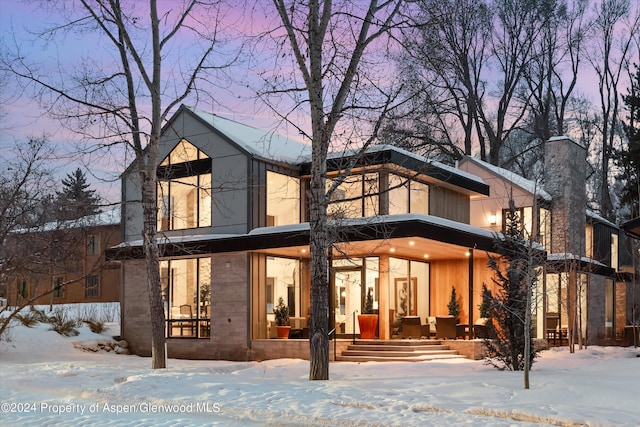 view of snow covered rear of property