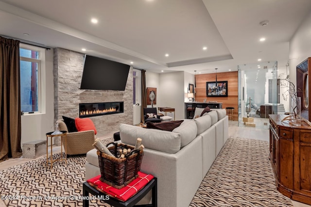 living room featuring a raised ceiling and a fireplace