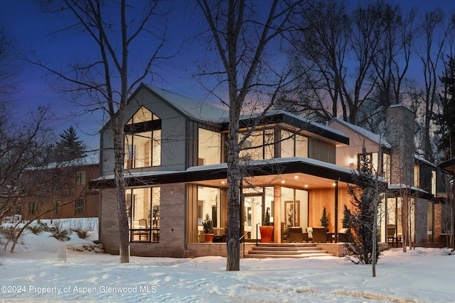 view of snow covered rear of property