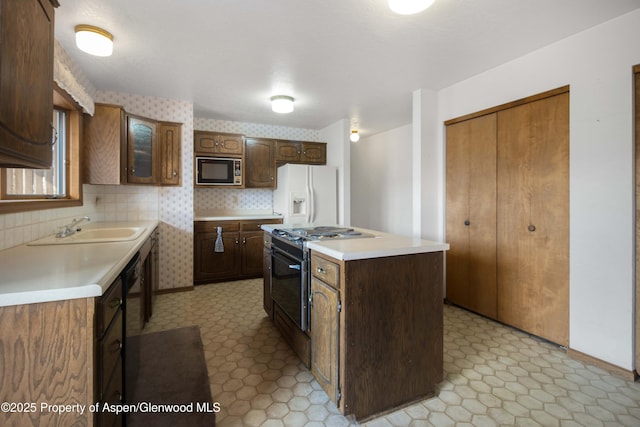 kitchen with built in microwave, sink, white refrigerator with ice dispenser, a center island, and gas range