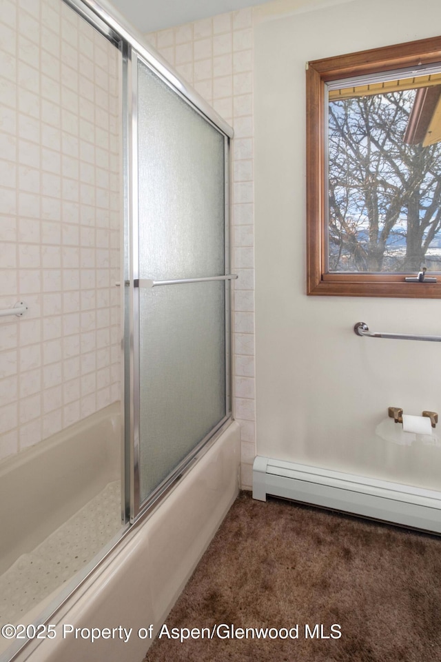 bathroom featuring a baseboard heating unit and bath / shower combo with glass door