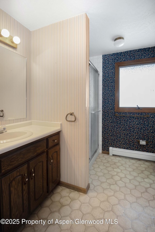 bathroom featuring vanity, walk in shower, and baseboard heating