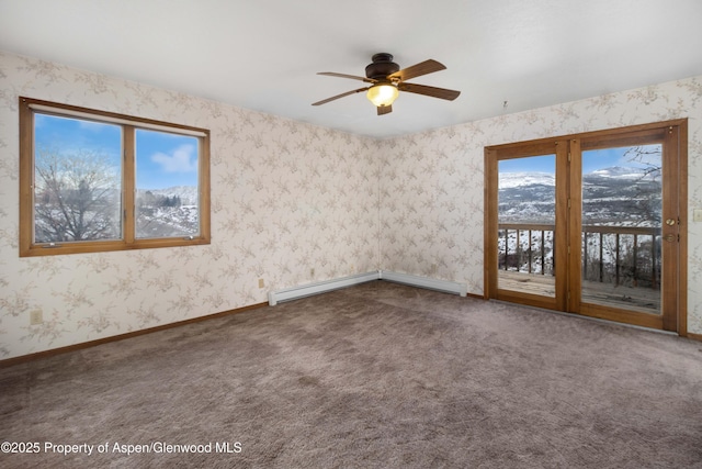 carpeted spare room with a mountain view and ceiling fan