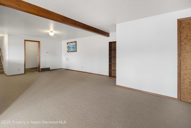 unfurnished room with carpet and beam ceiling