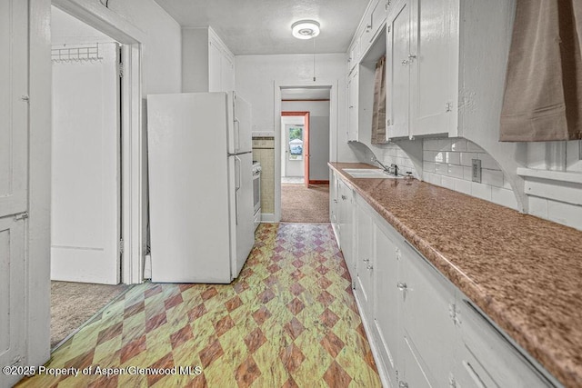 774 School St, Craig, CO 81625 - kitchen with freestanding refrigerator, white cabinetry, oven, light flooring, and backsplash