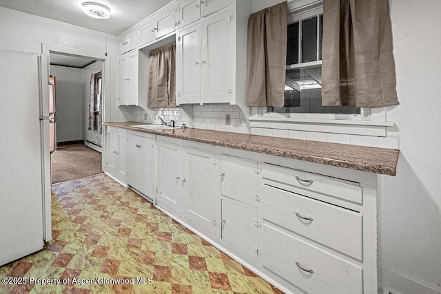 774 School St, Craig, CO 81625 - kitchen featuring freestanding refrigerator, white cabinets, and light flooring