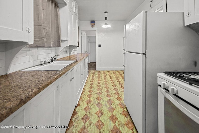 774 School St, Craig, CO 81625 - kitchen with white cabinetry, light floors, white appliances, and decorative backsplash