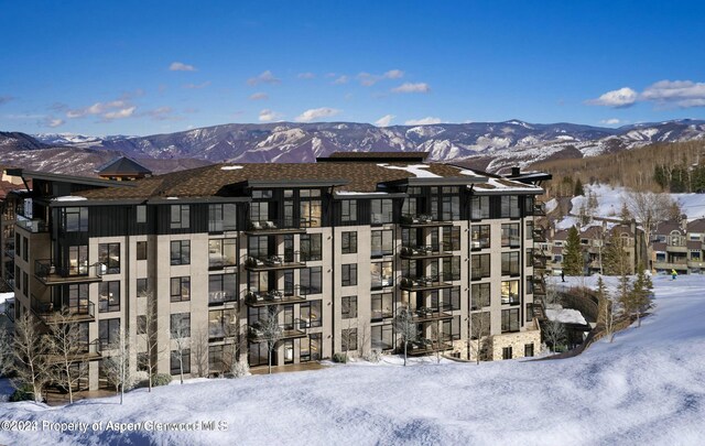 snow covered building featuring a mountain view