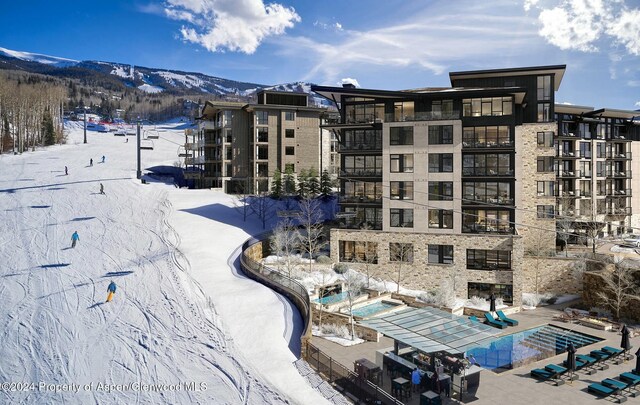 snow covered building featuring a mountain view