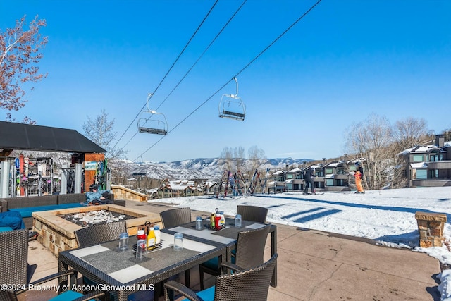 snow covered patio with a mountain view