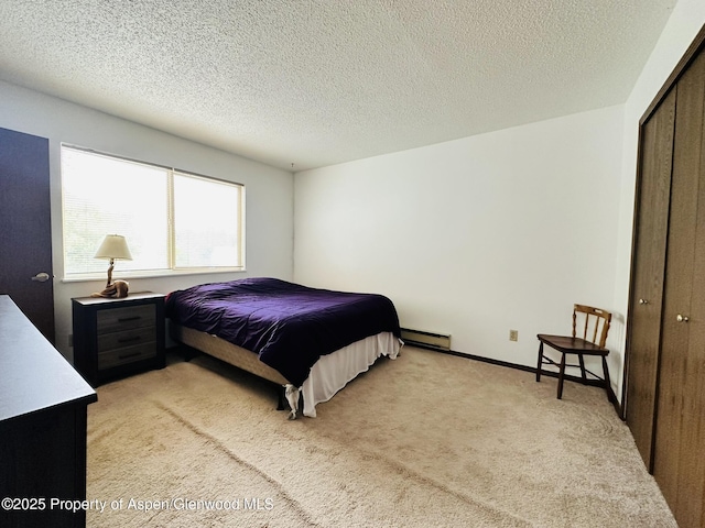 1024 E Ave, Rifle, CO 81650 - bedroom with light carpet, a closet, a baseboard radiator, and a textured ceiling