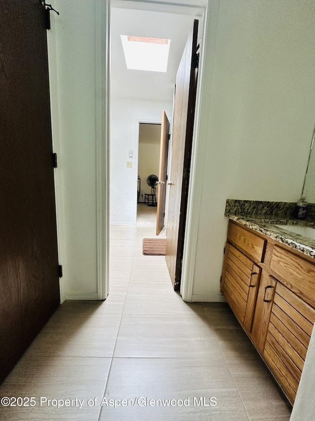 1024 E Ave, Rifle, CO 81650 - corridor featuring a skylight, light tile patterned flooring, and a sink