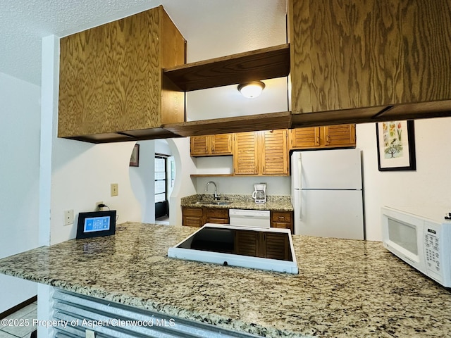 1024 E Ave, Rifle, CO 81650 - kitchen featuring white appliances, a sink, a peninsula, and light stone countertops