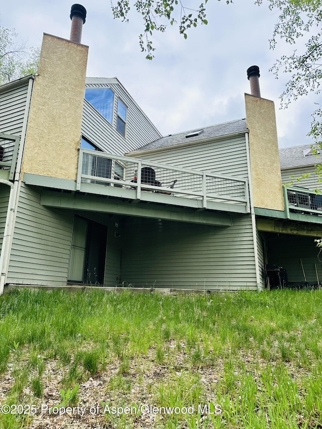 1024 E Ave, Rifle, CO 81650 - rear view of property with a balcony and a chimney