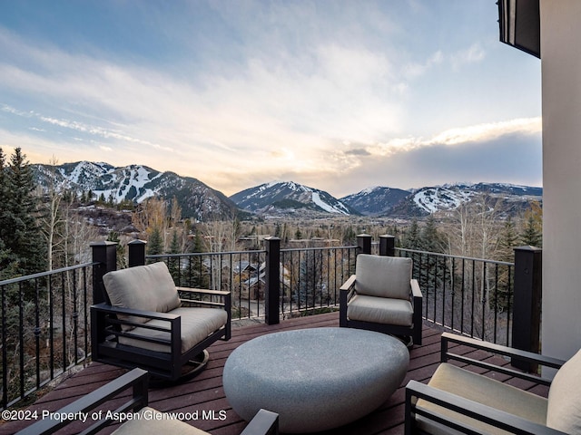 balcony at dusk featuring a mountain view