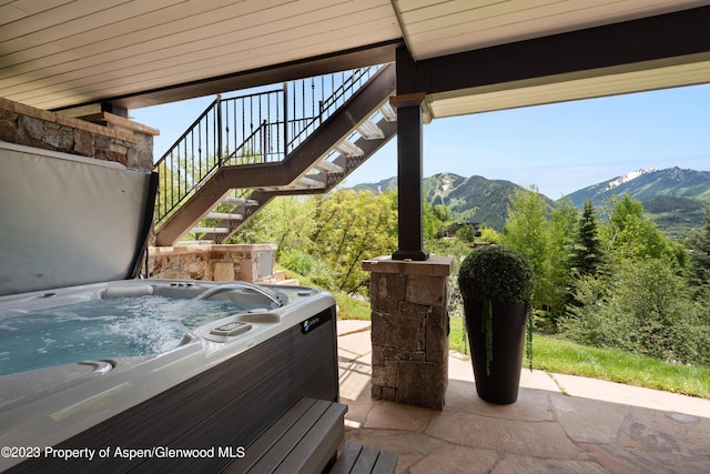 view of patio / terrace featuring a mountain view and a hot tub