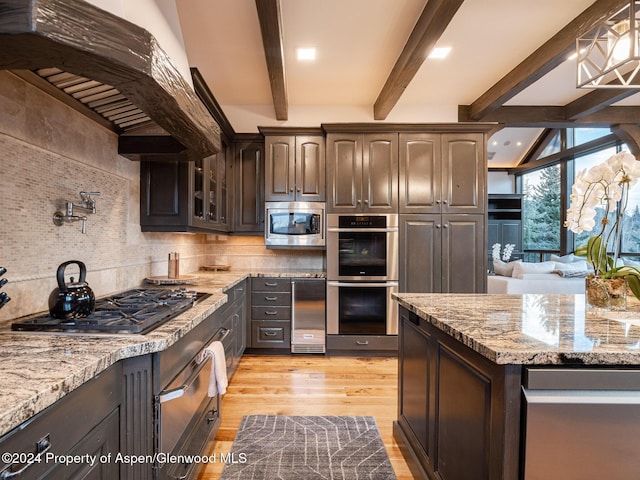 kitchen with decorative backsplash, appliances with stainless steel finishes, custom range hood, dark brown cabinetry, and beam ceiling