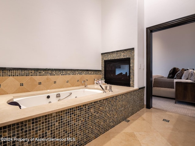 bathroom with tile patterned floors and tiled bath