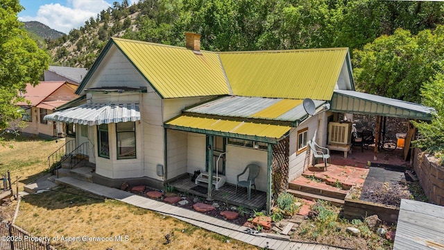 1012 Minter Ave, Glenwood Springs, CO 81601 - back of property featuring a metal roof, a chimney, a mountain view, and a patio