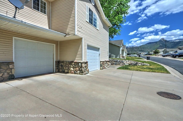 41 Angelica Cir, Parachute, CO 81635 - view of side of property featuring an attached garage, a mountain view, driveway, and stone siding
