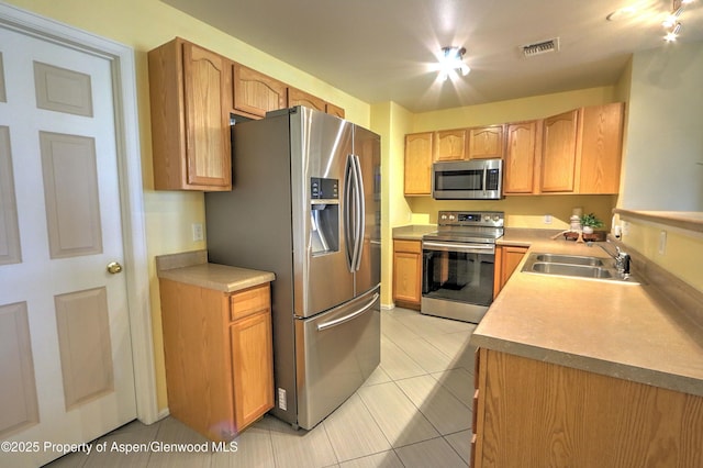 41 Angelica Cir, Parachute, CO 81635 - kitchen with stainless steel appliances, a sink, light tile patterned floors, and light countertops