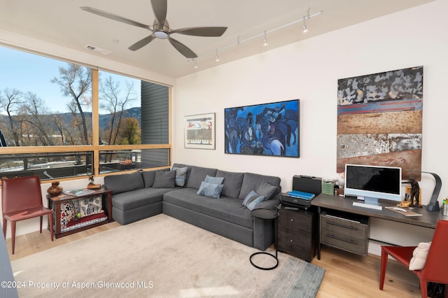 living room featuring ceiling fan and light hardwood / wood-style flooring