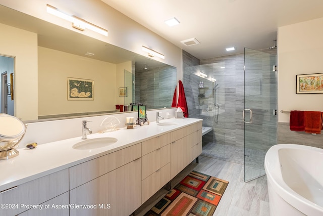 bathroom featuring wood-type flooring, vanity, and separate shower and tub