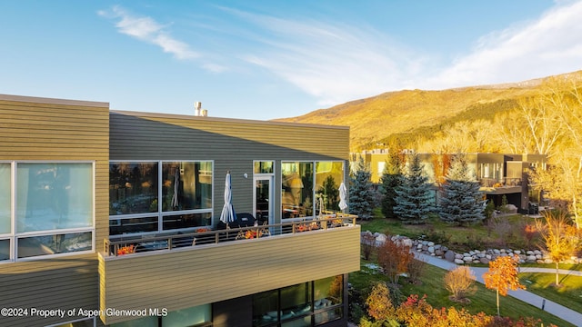 back of house featuring a mountain view and a balcony