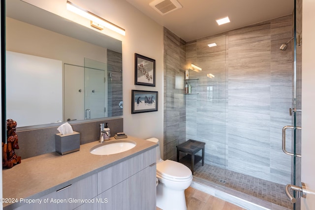 bathroom with walk in shower, vanity, and toilet